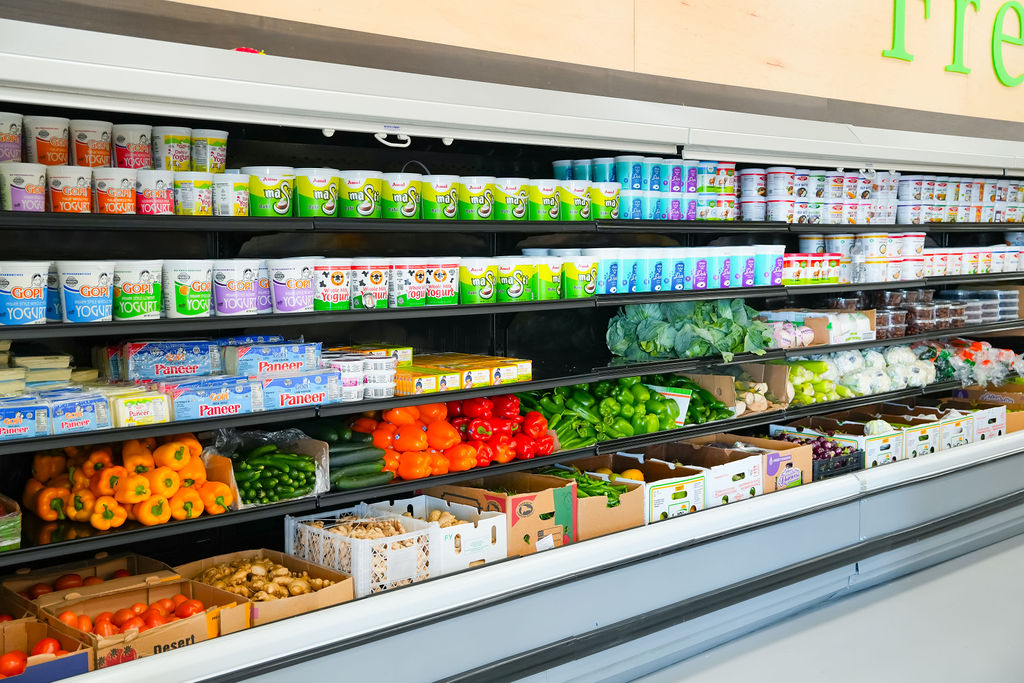 Yogurt, paneer, and fresh peppers in the Reliance Mart produce cooler